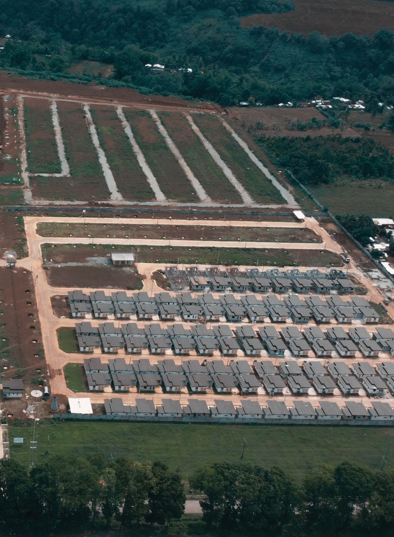 Aerial drone photo of Menzi New Town showing completed housing rows and land prepared for future phases